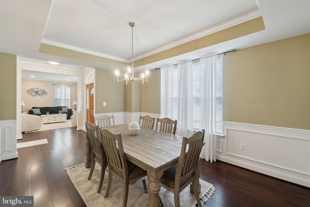 dining room with dark hardwood / wood-style flooring, crown molding, a raised ceiling, and a chandelier