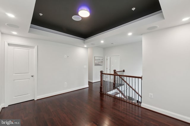 unfurnished room featuring dark hardwood / wood-style flooring and a raised ceiling