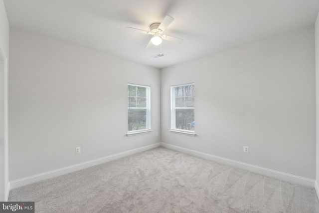 spare room featuring light carpet and ceiling fan