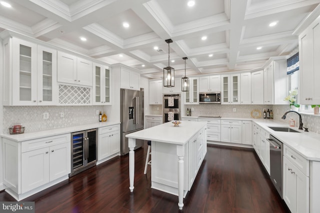 kitchen featuring sink, decorative light fixtures, appliances with stainless steel finishes, a kitchen island, and white cabinets