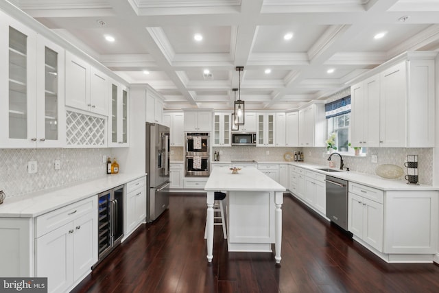 kitchen with wine cooler, stainless steel appliances, a center island, and white cabinets