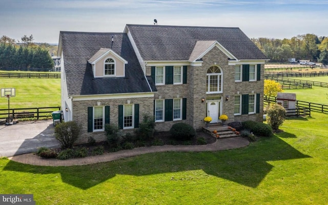 view of front of home with a front yard and a rural view