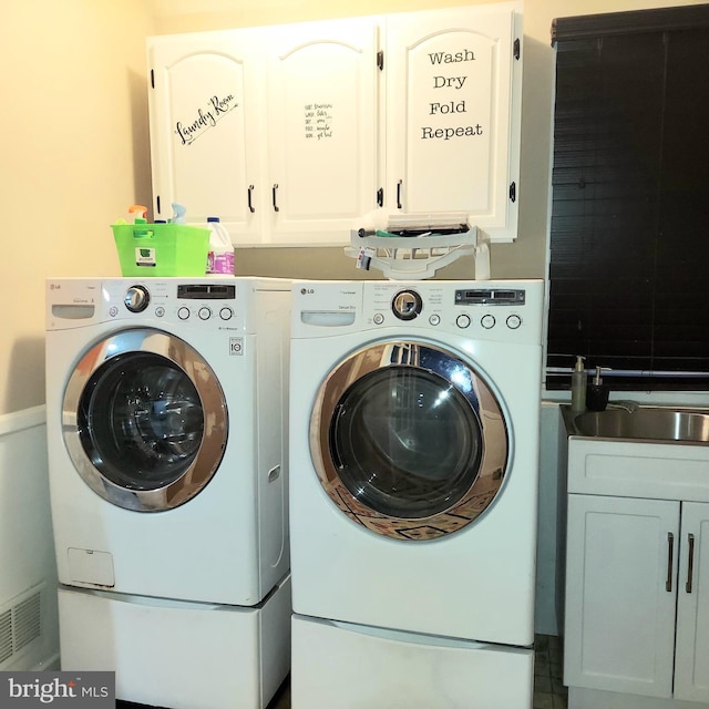 laundry room with washing machine and dryer and cabinets