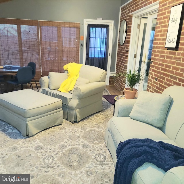 living room featuring wood-type flooring and brick wall