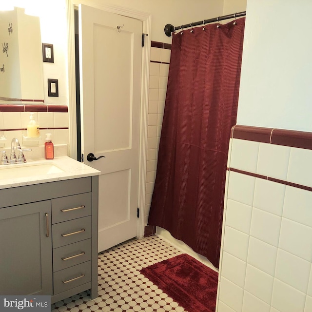 bathroom with vanity, a shower with shower curtain, and tile walls