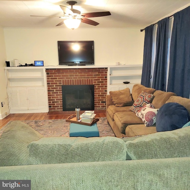 living room featuring hardwood / wood-style flooring, ceiling fan, and a fireplace