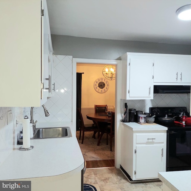 kitchen featuring range hood, tasteful backsplash, sink, white cabinets, and black electric range