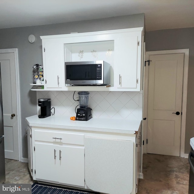 kitchen with decorative backsplash and white cabinets