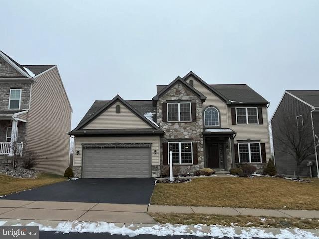 view of front of house with a garage and a lawn