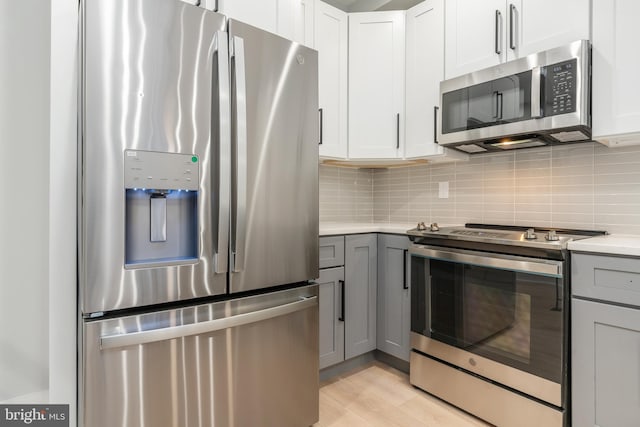 kitchen featuring tasteful backsplash, gray cabinets, and stainless steel appliances