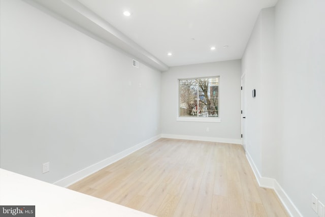 empty room with light wood finished floors, recessed lighting, visible vents, and baseboards