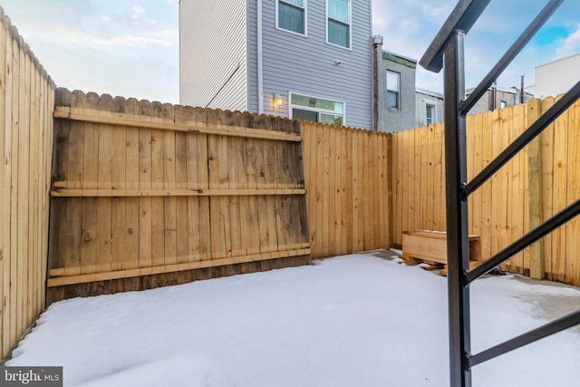 snowy yard featuring fence