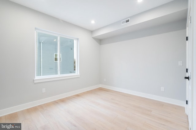 spare room featuring light wood-style floors, baseboards, visible vents, and recessed lighting