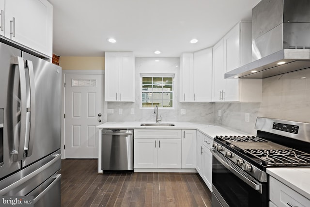 718 Collington Ave, Baltimore, MD 21205 - kitchen featuring appliances with stainless steel finishes, white cabinetry, sink, backsplash, and wall chimney exhaust hood