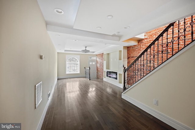 718 Collington Ave, Baltimore, MD 21205 - foyer featuring ceiling fan, wood-type flooring, a tray ceiling, and brick wall