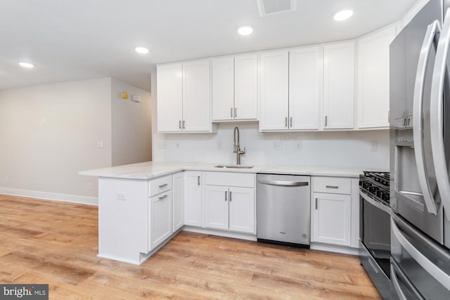 kitchen featuring sink, light wood-type flooring, kitchen peninsula, stainless steel appliances, and white cabinets