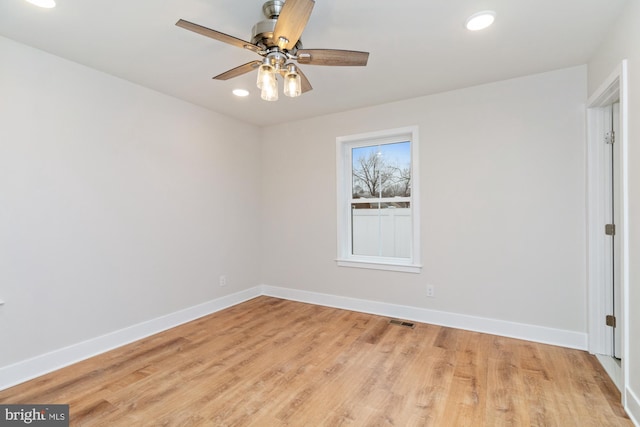 spare room with ceiling fan and light wood-type flooring