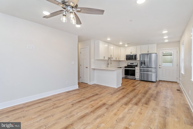 kitchen featuring sink, appliances with stainless steel finishes, ceiling fan, light hardwood / wood-style floors, and white cabinets