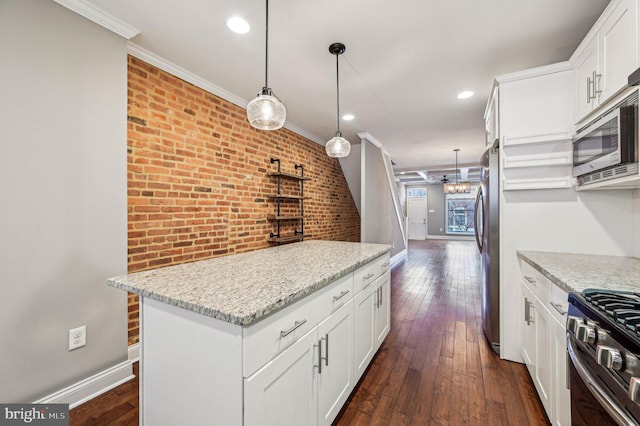 kitchen featuring light stone counters, white cabinetry, crown molding, pendant lighting, and stainless steel appliances