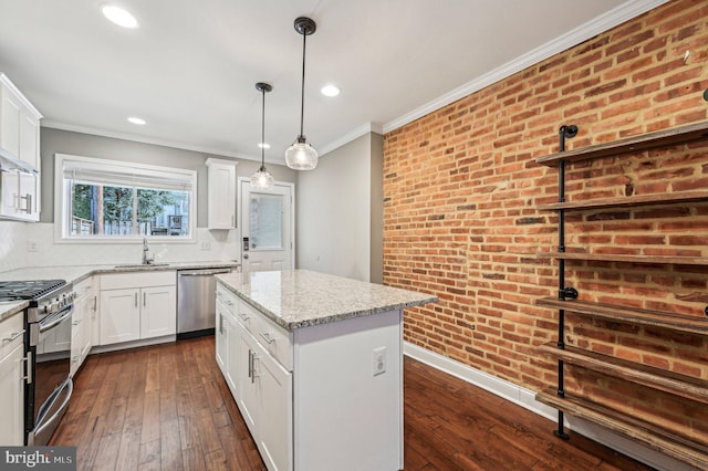 kitchen with stainless steel appliances, a kitchen island, white cabinets, and light stone counters