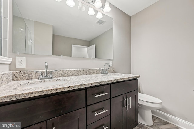 bathroom featuring vanity and toilet