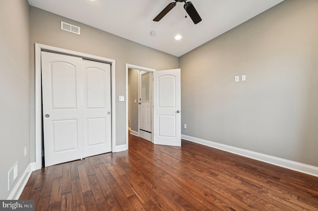 unfurnished bedroom with ceiling fan, dark hardwood / wood-style flooring, and a closet