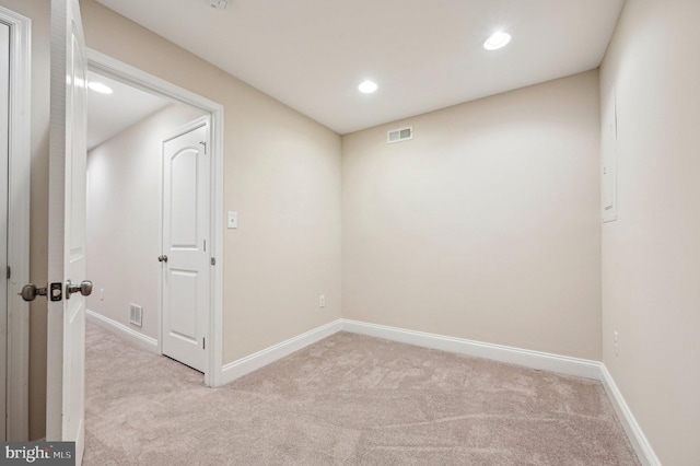 spare room featuring light carpet