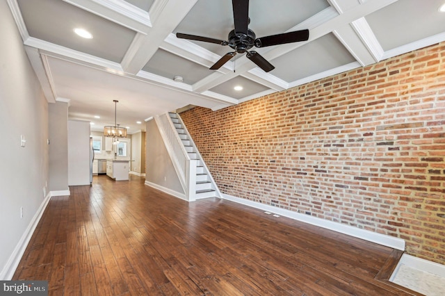 unfurnished living room with beamed ceiling, brick wall, coffered ceiling, and dark hardwood / wood-style flooring