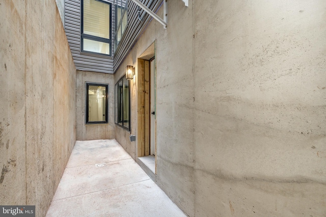 hallway featuring concrete floors and a high ceiling