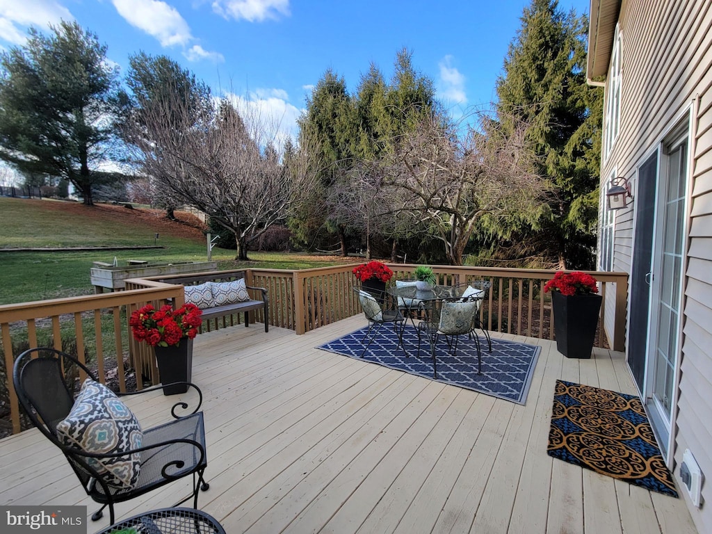 wooden deck featuring a lawn