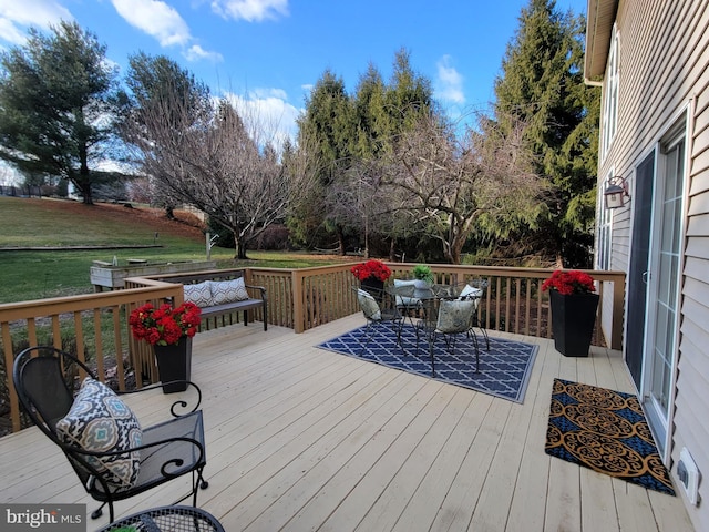 wooden deck featuring a lawn