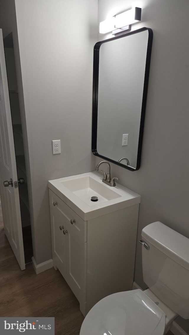 bathroom with toilet, wood-type flooring, and vanity