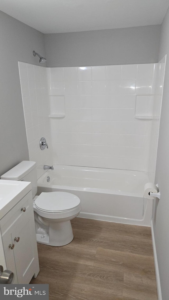 full bathroom with vanity, bathing tub / shower combination, hardwood / wood-style floors, and toilet