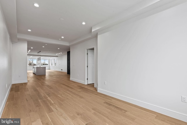 unfurnished living room featuring recessed lighting, light wood-type flooring, and baseboards