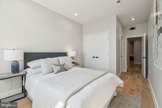 bedroom featuring visible vents, recessed lighting, a closet, light wood finished floors, and baseboards