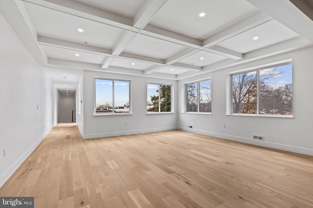 empty room featuring beam ceiling, light wood-style floors, visible vents, and coffered ceiling