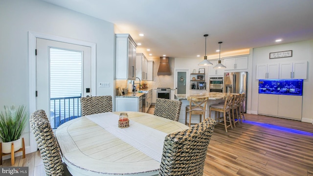 dining room with sink and light hardwood / wood-style flooring