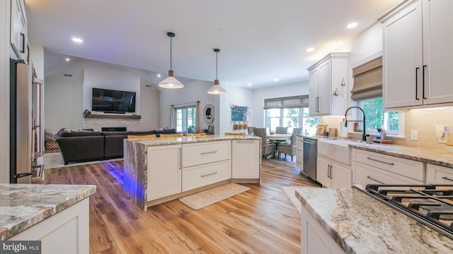 kitchen with white cabinetry, stainless steel appliances, and light stone counters