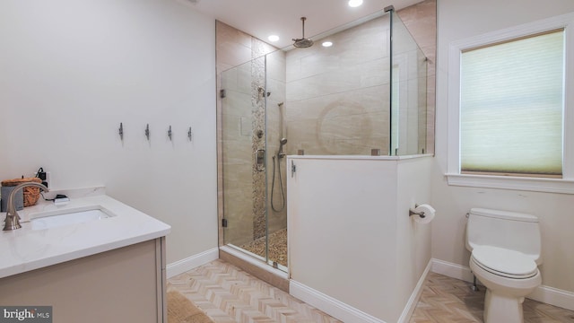 bathroom featuring parquet flooring, vanity, toilet, and a shower with shower door