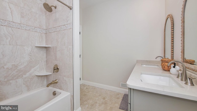 bathroom featuring tiled shower / bath and vanity