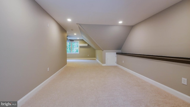 bonus room featuring lofted ceiling, a wall mounted air conditioner, and light carpet