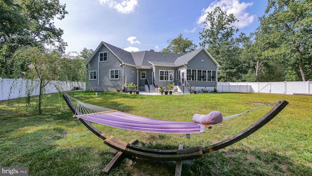 back of property with a yard and a sunroom