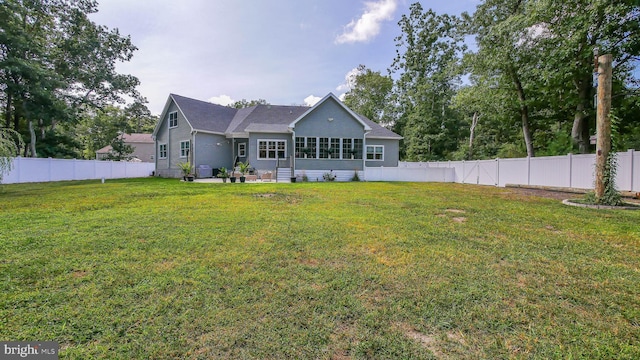 rear view of house with a patio and a lawn