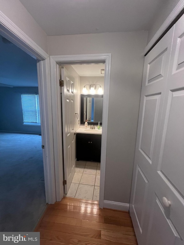 corridor featuring sink and light hardwood / wood-style flooring