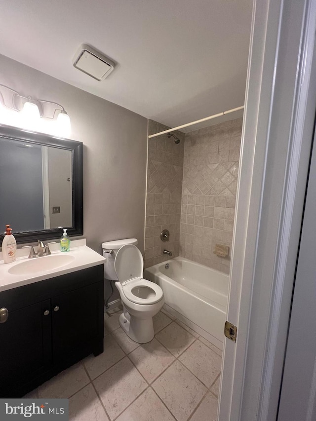 full bathroom with tiled shower / bath combo, vanity, tile patterned floors, and toilet