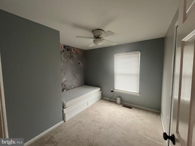 unfurnished bedroom with ceiling fan and light colored carpet