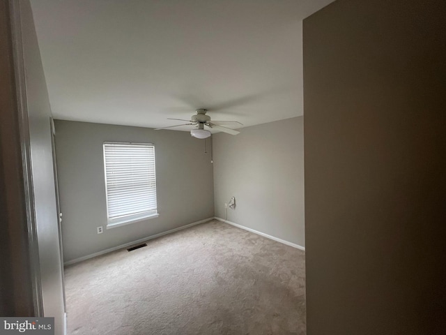 spare room featuring ceiling fan and light carpet