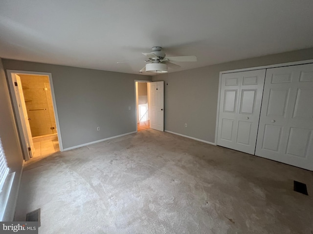 unfurnished bedroom with ceiling fan, ensuite bath, and a closet