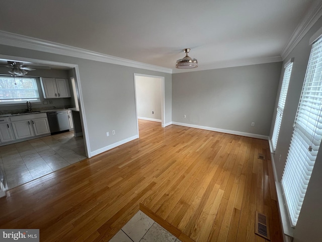 unfurnished living room with crown molding, ceiling fan, light hardwood / wood-style floors, and sink