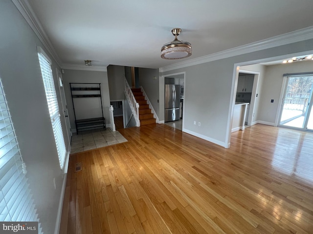 unfurnished living room with crown molding and light hardwood / wood-style floors